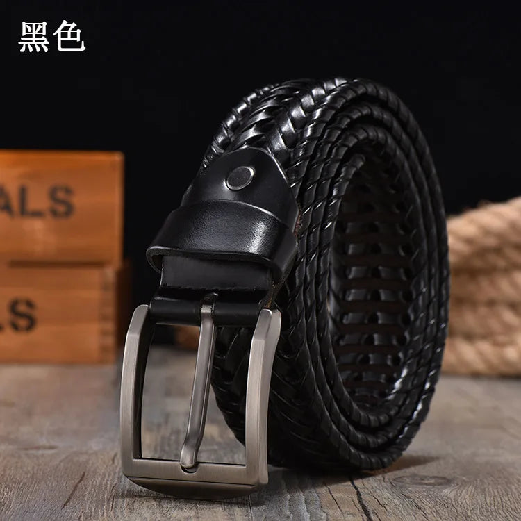 Black woven belt with silver buckle on a wooden surface