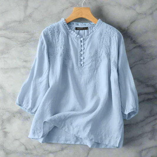Light blue shirt on a hanger with prymee branding.