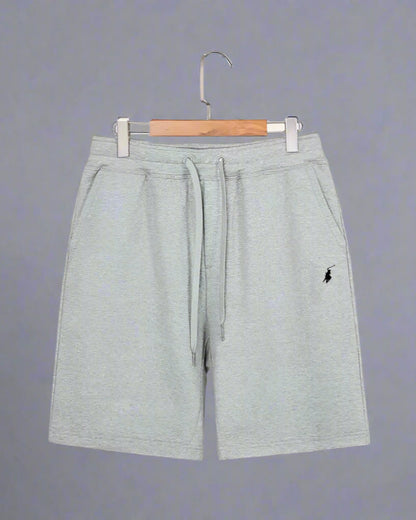 Gray shorts with a small logo on a hanger against a white background