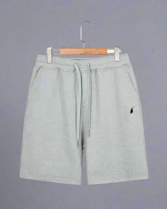 Gray shorts with a small logo on a hanger against a white background
