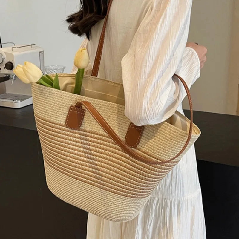 Person holding a straw tote bag with flowers, wearing a white outfit.