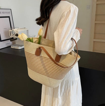 Person holding a woven tote bag with flowers indoors